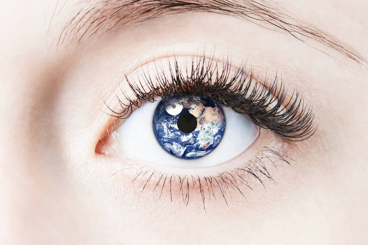 closeup of woman's eye with reflection of an image of the world