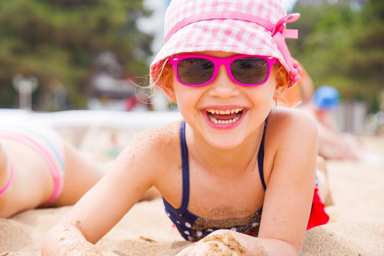 Girl toddler wearing sunglasses on the beach